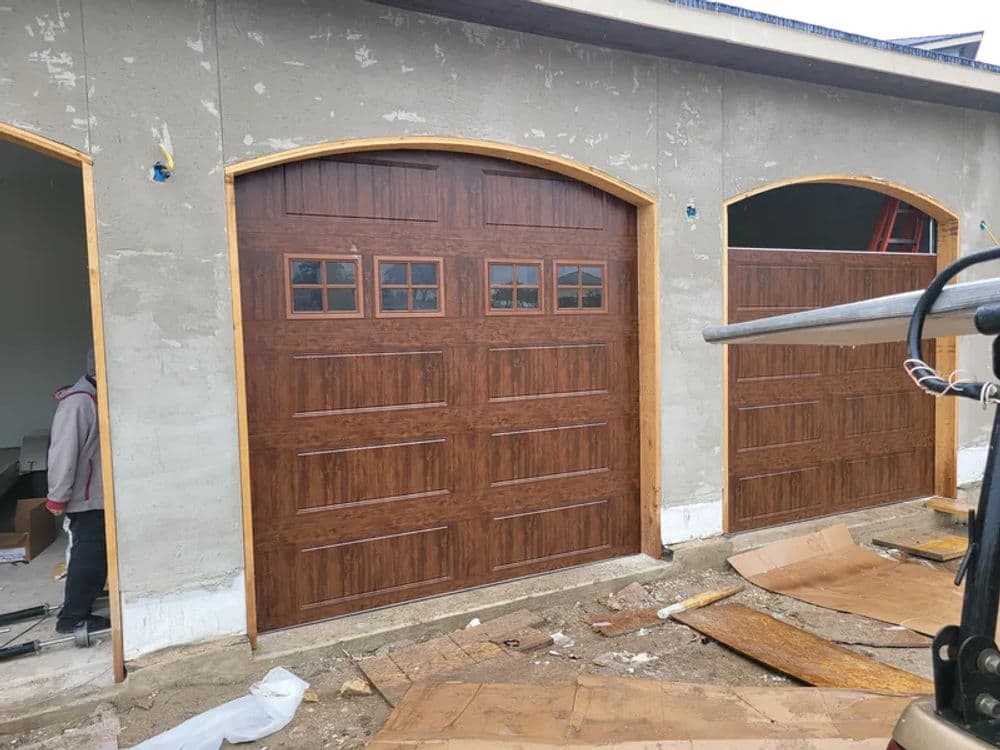 Wooden garage doors installed in a residential building under construction.